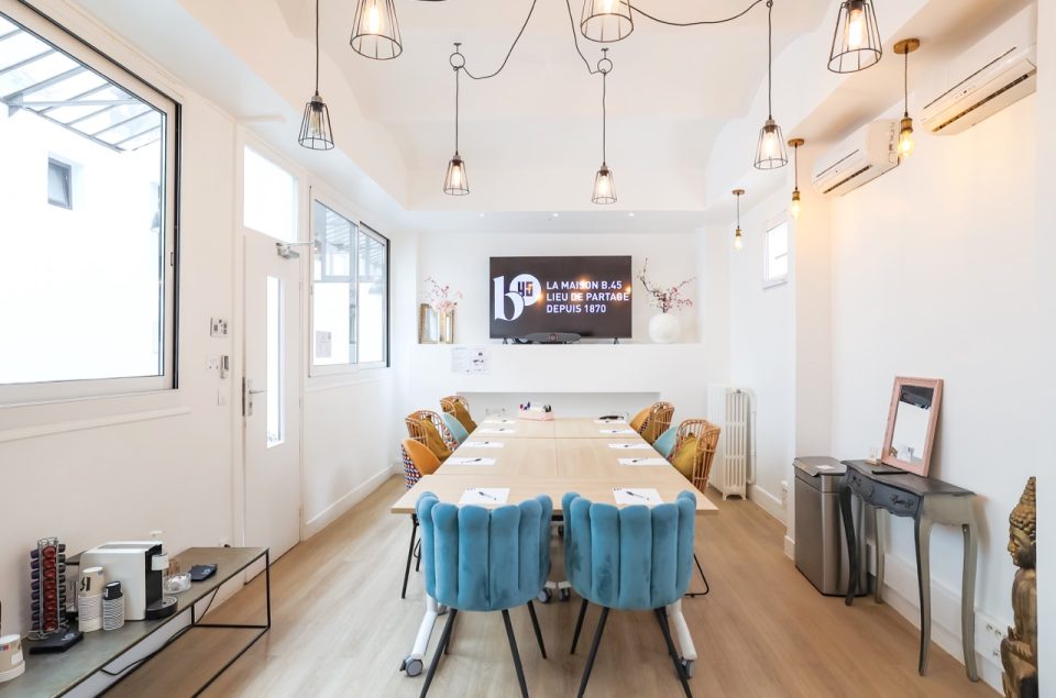 Salle Lainé-Lafarie vu de face avec table en rectangle et chaise devant la télévision