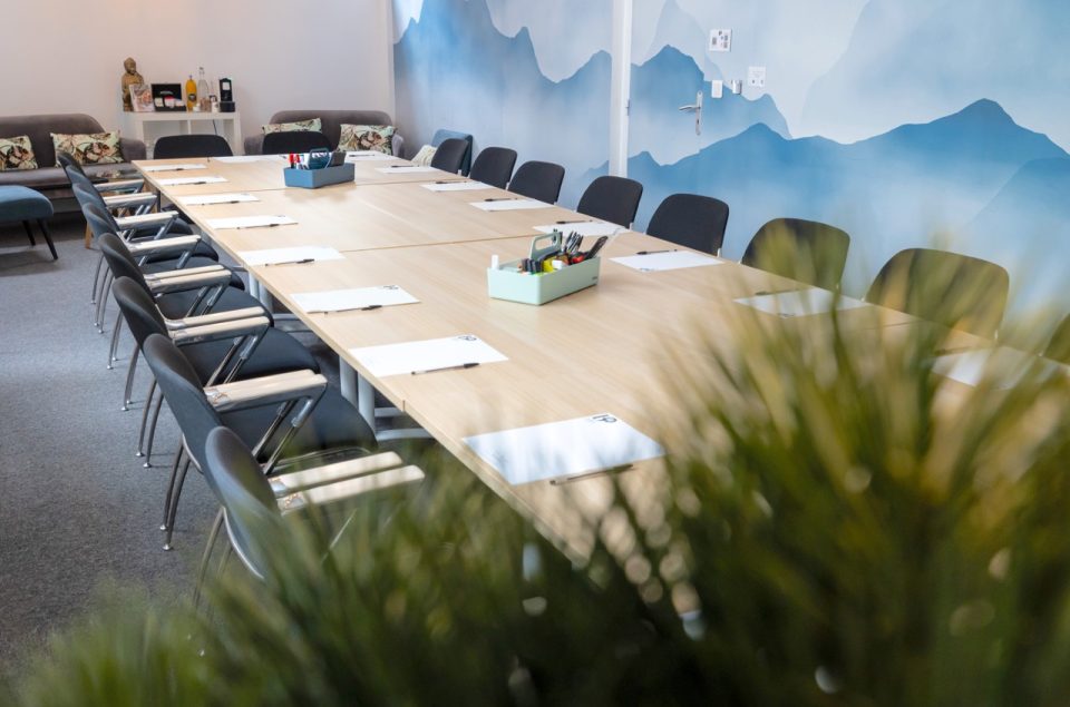 Salle Gustave avec papier pin imprimé montagne bleu et table en disposition bureau avec kit papeterie sur la table