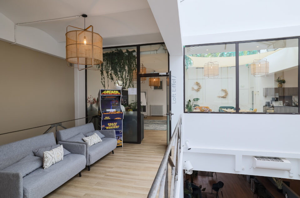 Couloir qui emmène au Loft Eiffel avec canapé et jeu d'Arcade