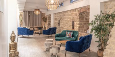 Salle Les Chais avec table basse en bois et canapé en velours bleu