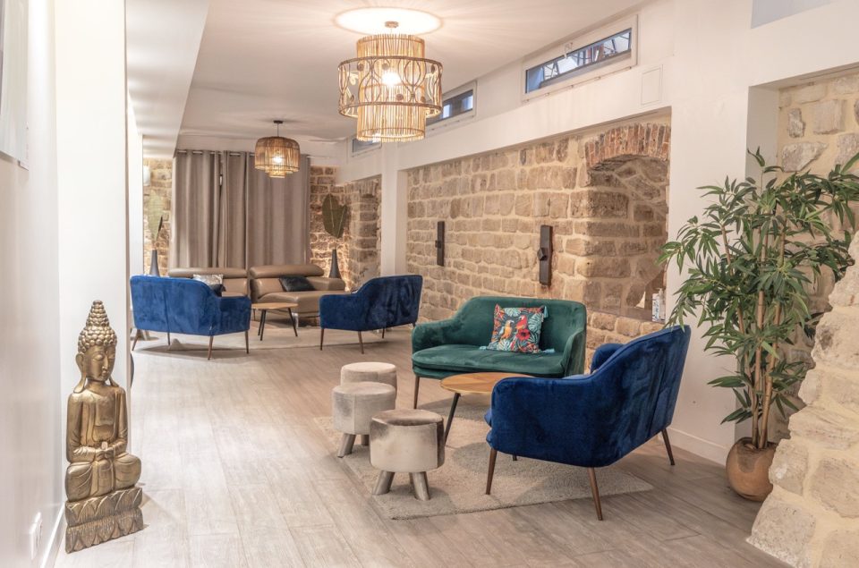 Salle Les Chais avec table basse en bois et canapé en velours bleu