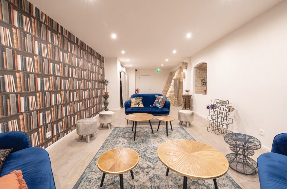 Salle Les Chais avec table basse en bois et canapé en velours bleu