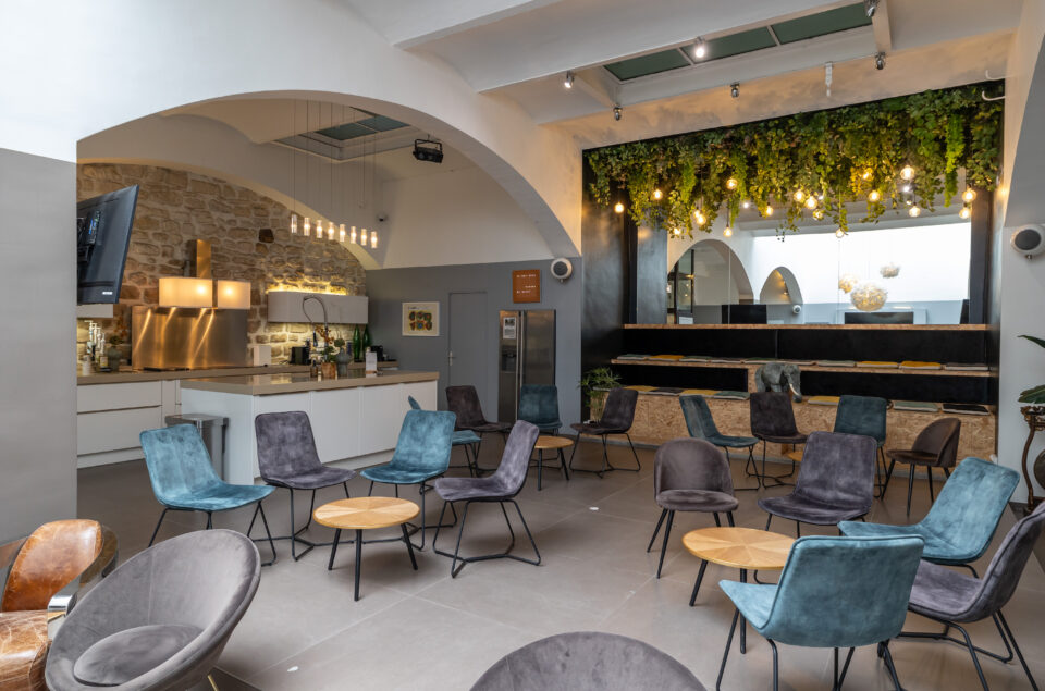 Chaise en arc de cercle autour d'unne table basse dans le grand Loft avec cuisine en arrière plan