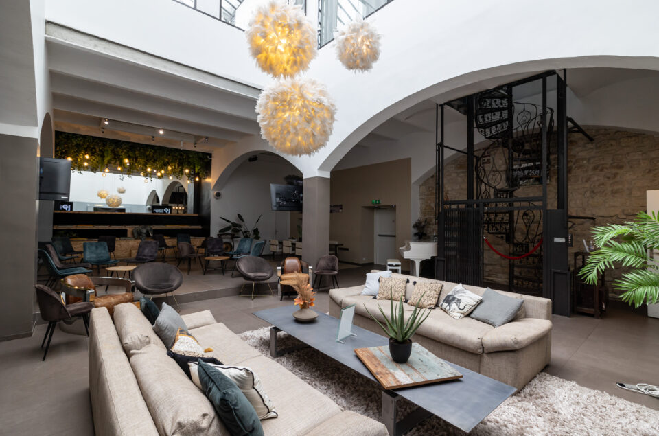 Grand Loft avec vision des canapé et chaises au fond. Escalier en colimaçon au fond