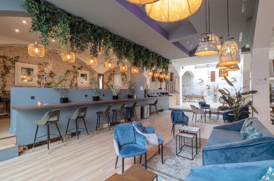 Salle Lounge avec vision directe su les plans de travail à l'entrée et les canapés bleus