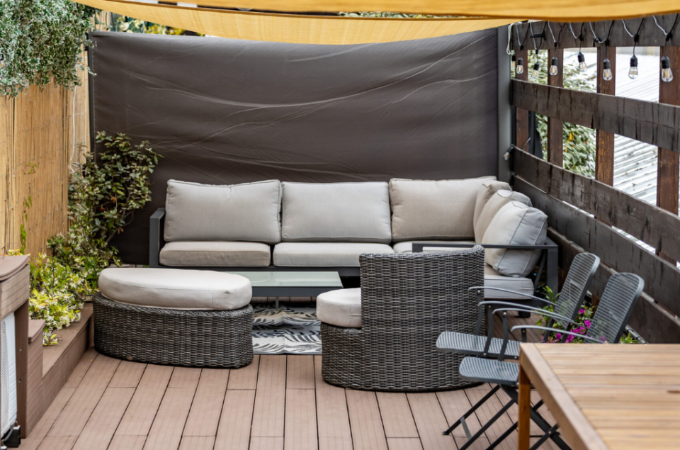 Canapé intimiste sur le rooftop avec une toile tendue pour se protéger du soleil
