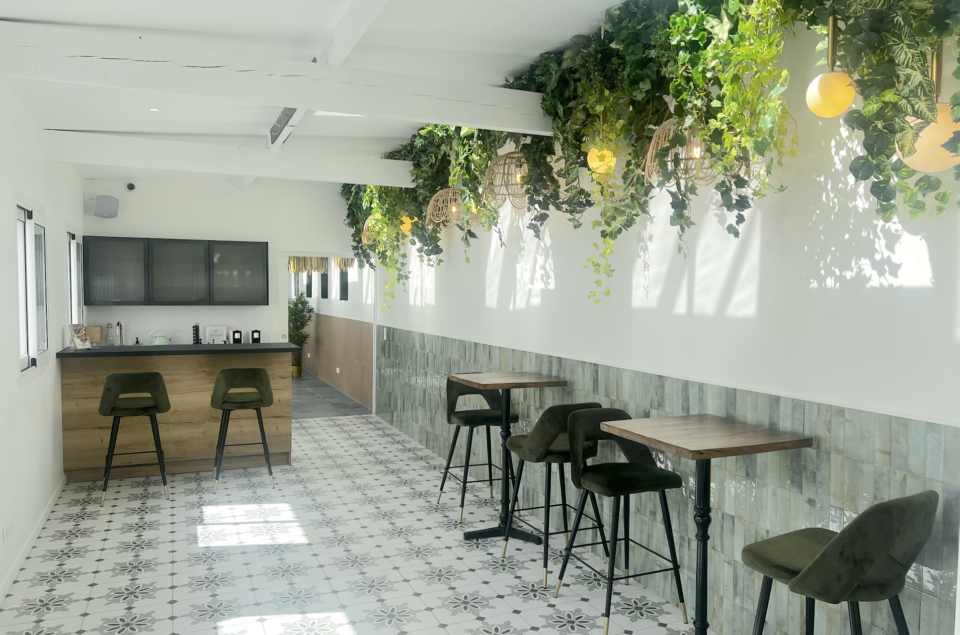 Salon Alcia avec tables de 2 personnes sur le coté avec chaises en velours kaki assorties aux tabourets du bar