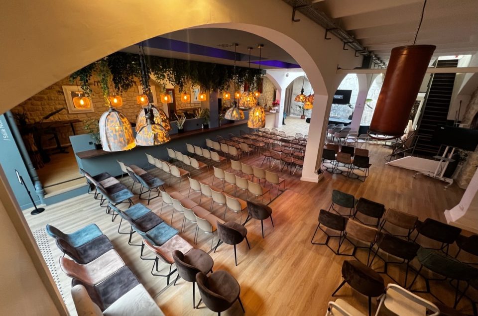 Disposition théâtre dans la salle lounge avec des chaises tout le long vue de dos