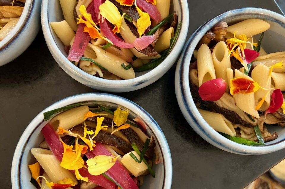 Zoom sur les verrines de salade de pattes champignons, ciboulette, oignons, pattes et fleurs comestibles