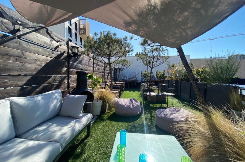 rooftop vu d'un canapé avec en face une table basse et pouf au sol
