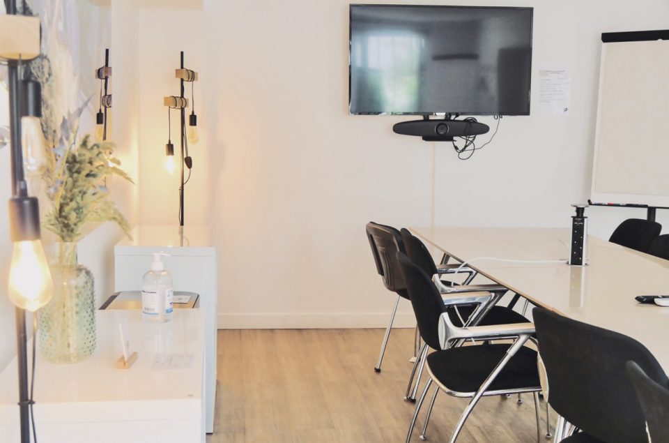 Salle Cour avec table chaise meuble et télé accrochée au mur